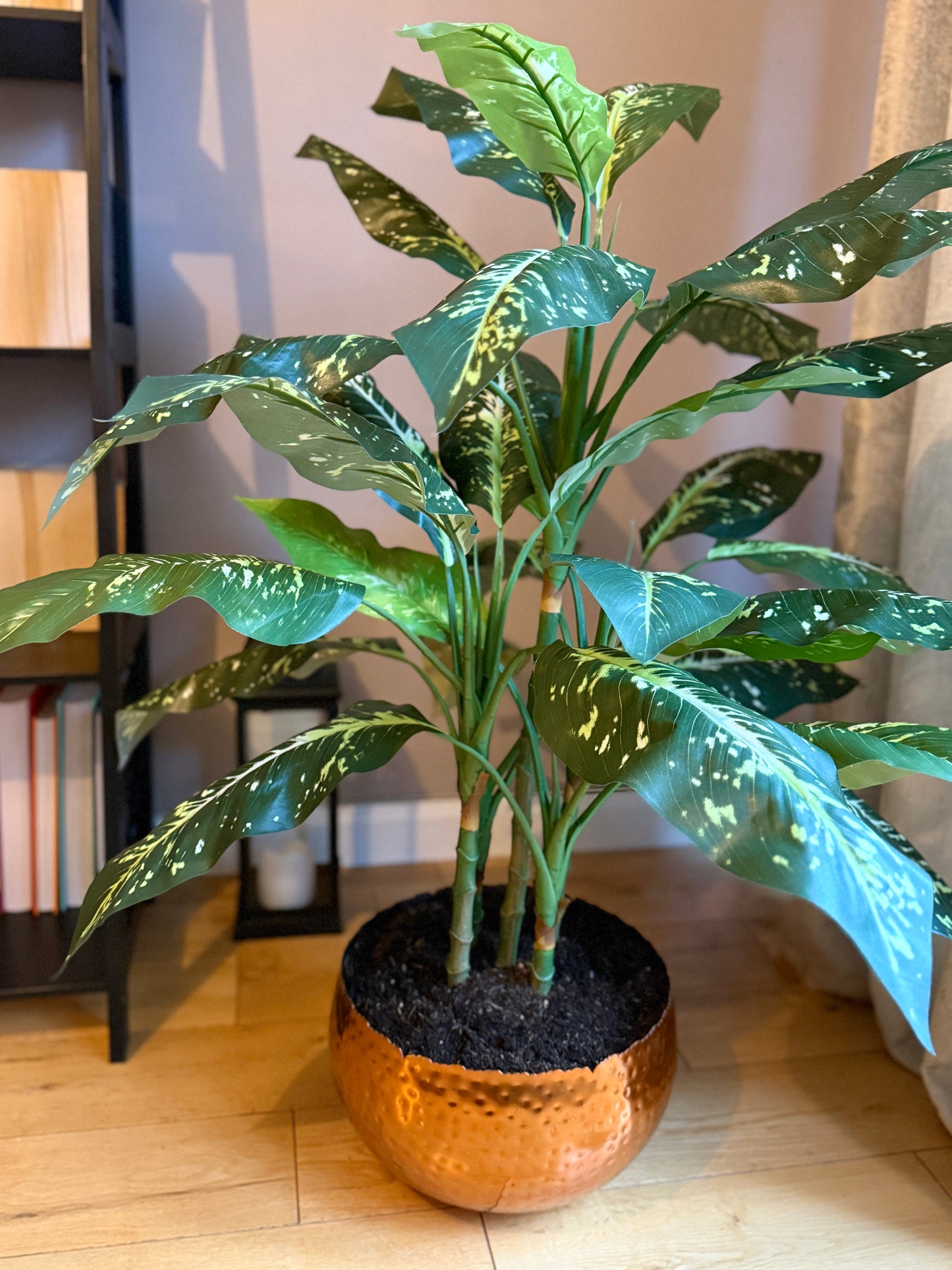 Back view of the Plantish artificial Aglaonema, showcasing its full leafy display, with rich green variegation, potted in a hammered copper metal planter.