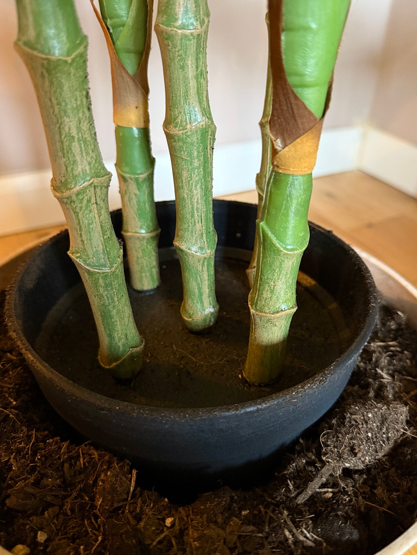 Close-up of the Plantish artificial Aglaonema stems, revealing the textured, natural looking stalks and black pot.