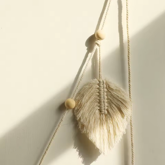 A close up of one leaf on the Plantish Bohemian White Leaf Macramé, highlighting the detailed cotton strands, string, and beads.