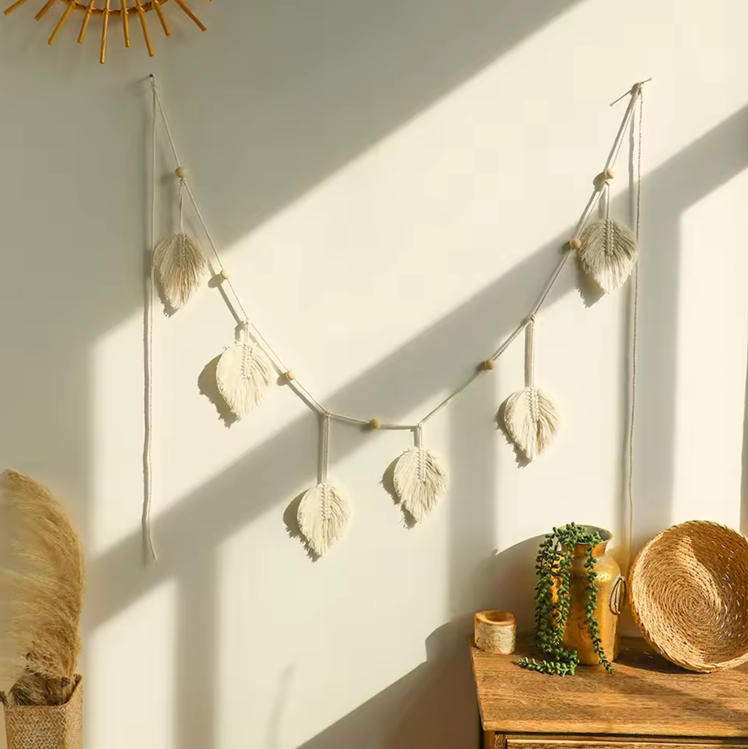 The Plantish Bohemian White Leaf Macramé hanging on a wall with natural light and rustic decor elements.