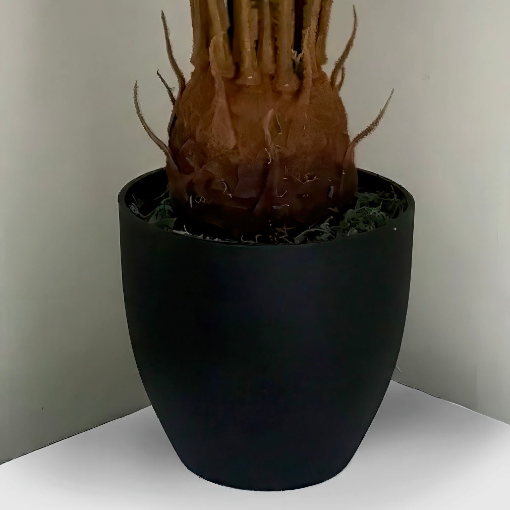 Close up of the Plantish artificial cycas palm, highlighting the ultra-realistic textured stump in the moss covered base and black pot.