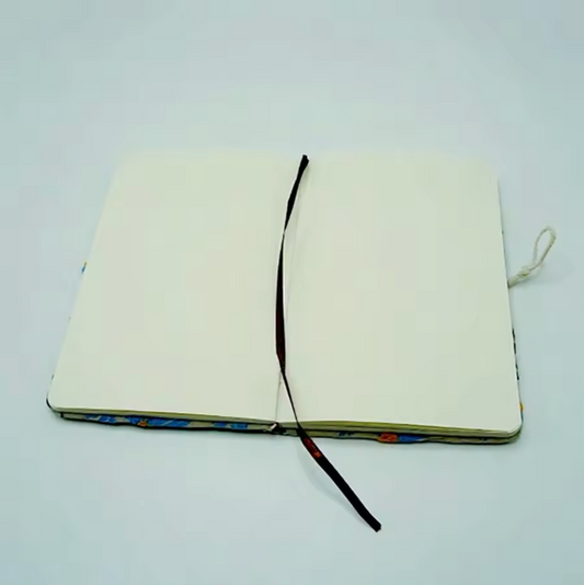 The Plantish Embroidered Little Daisy Notebook shown open against a white background. The inside is blank, and there is a fabric page marker visible.
