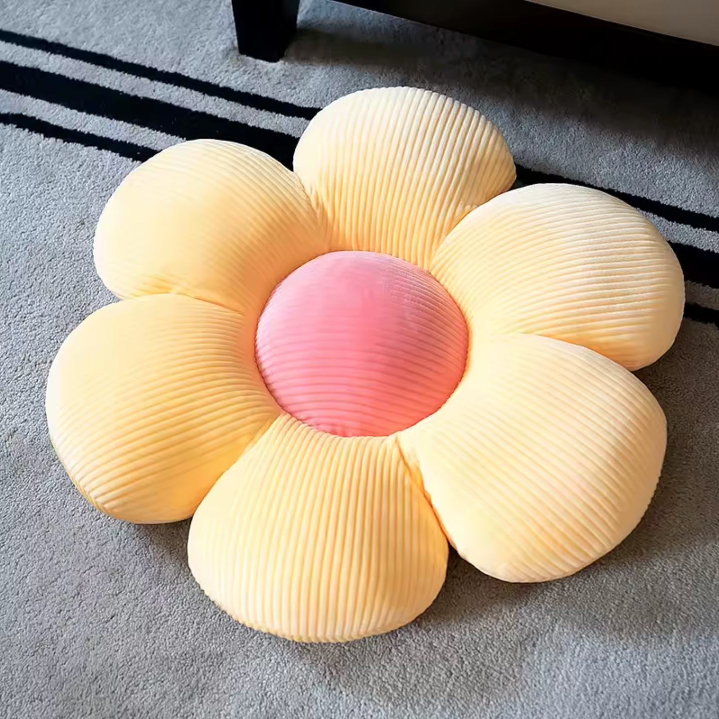 The Plantish Flower Plush Pillow in its
Yellow/Pink colour variant. The pillow is flower shaped with the petals being yellow and the centre pink.