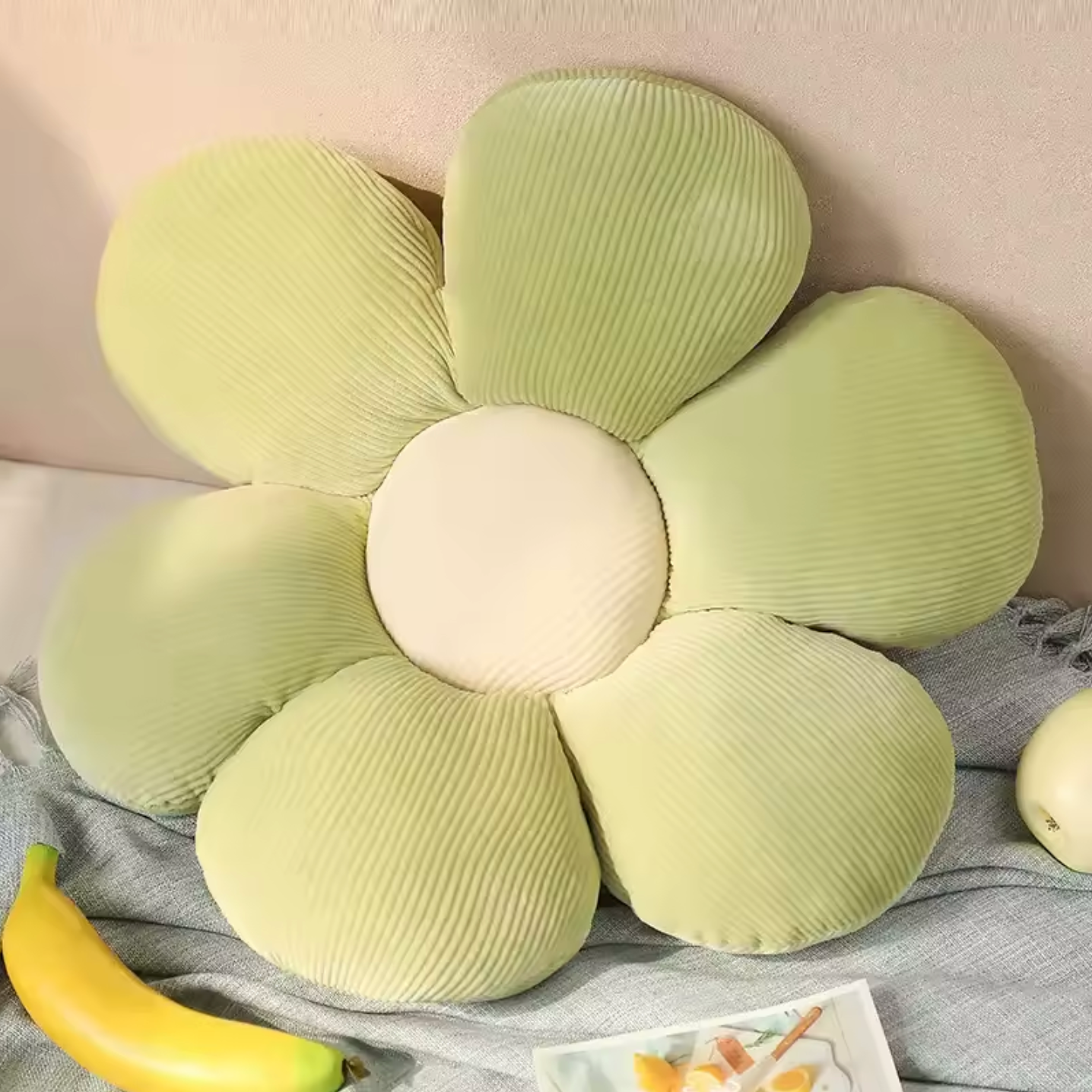 The Plantish Flower Plush Pillow in its
Green/White colour variant. The pillow is flower shaped with the petals being green and the centre white.