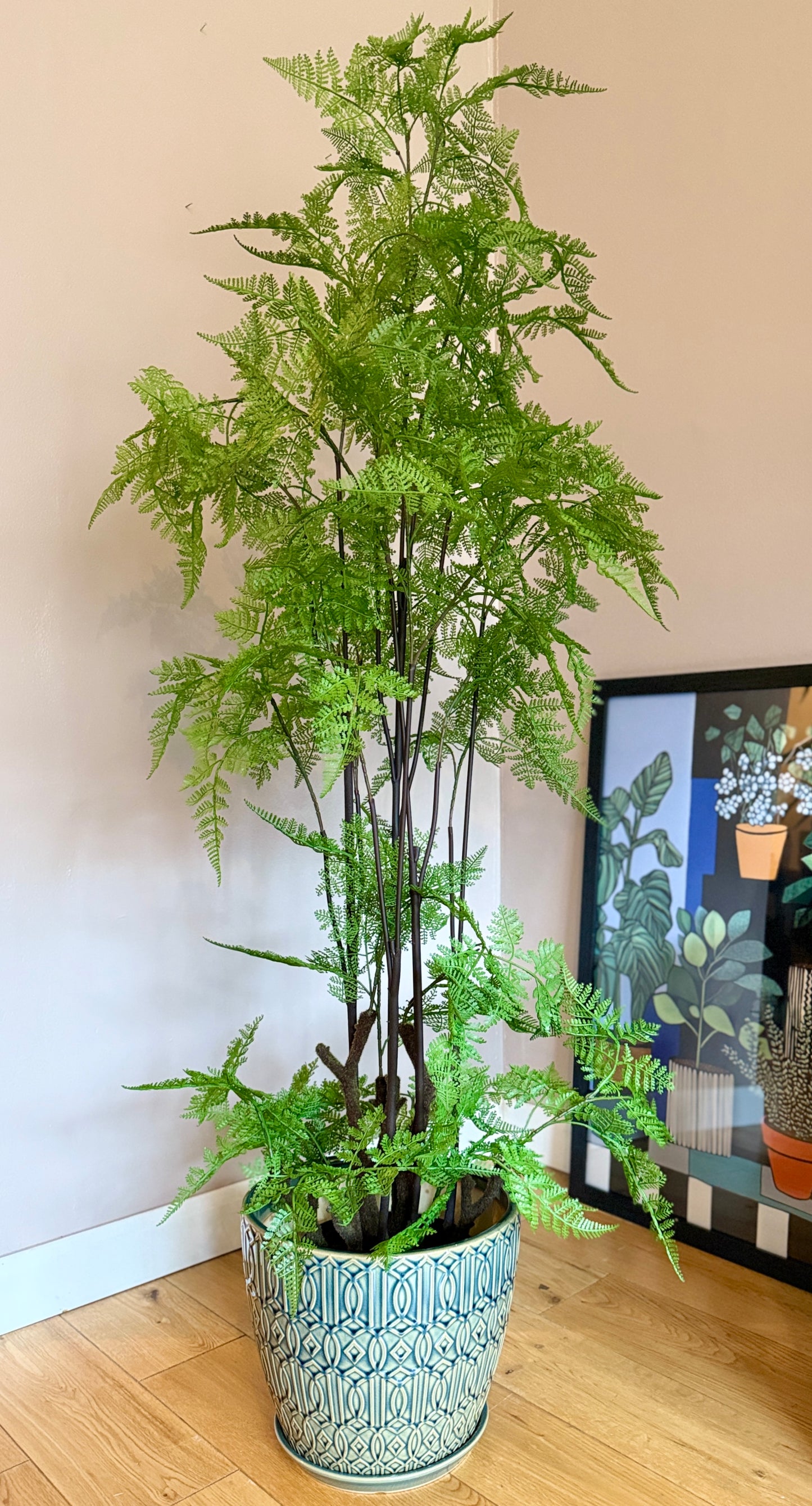 Front view of a tall Plantish artificial felce fern with vivid green fronds, potted in a ceramic teal-green pot.