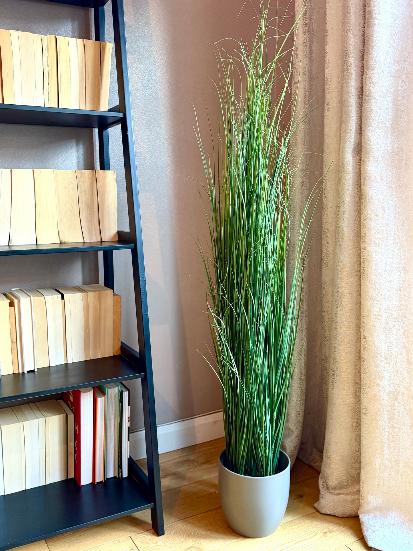 Front view of the Plantish artificial Onion Grass with tall, vibrant green blades, potted in a grey ceramic plant pot.