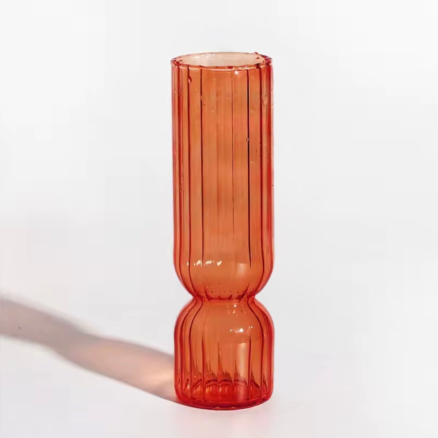 A close up of the Plantish Little Nordic Vase, orange colour option. The vase is on a white background.