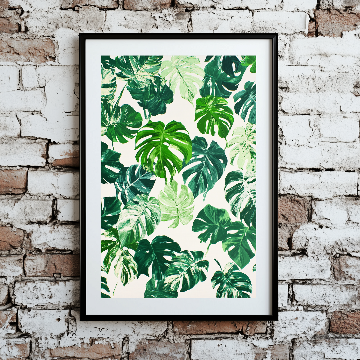 A vibrant and bright plant pattern print of monstera leaves, in different shades of green and some variegated with white, framed on a brick wall.