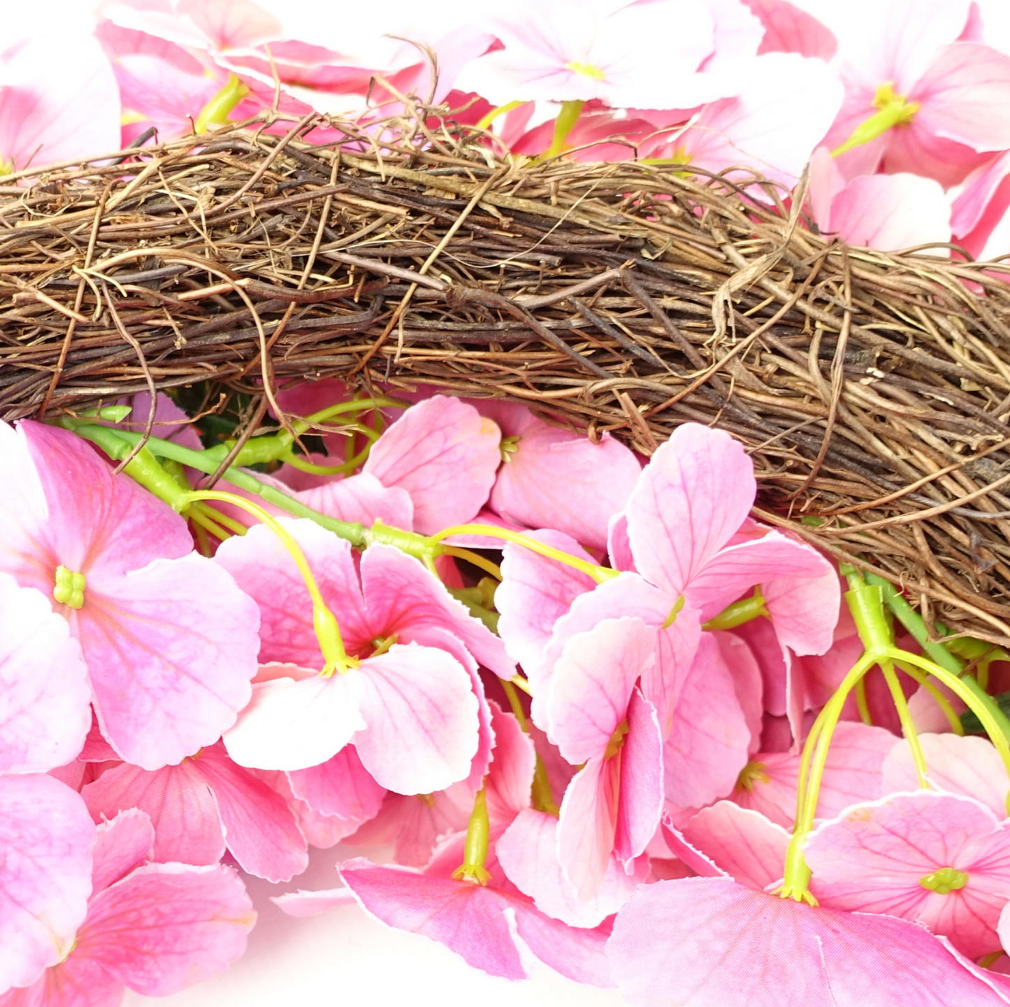 A close up of the Plantish 40cm Pink Cherry Blossom Wreath highlighting the vibrant pink cherry blossom flowers and the natural woven ring made of wood.