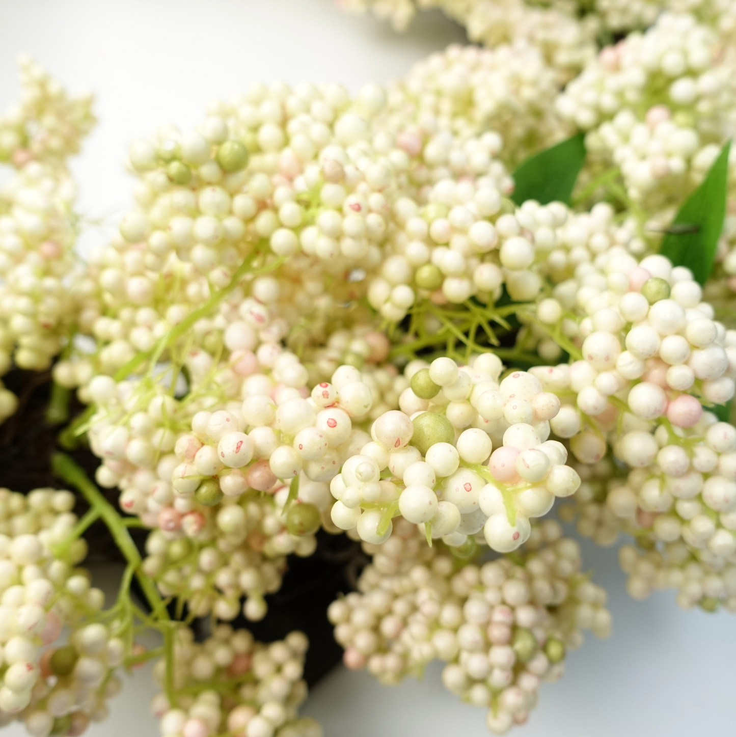 A close up of the Plantish 55cm White Berry Wreath, showing the white berries in a lot of detail.