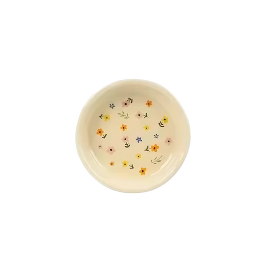 An image of the Plantish Wildflower Sauce Dish, highlighting the irregular shape and little multicolour flower design. The dish is on a white background.