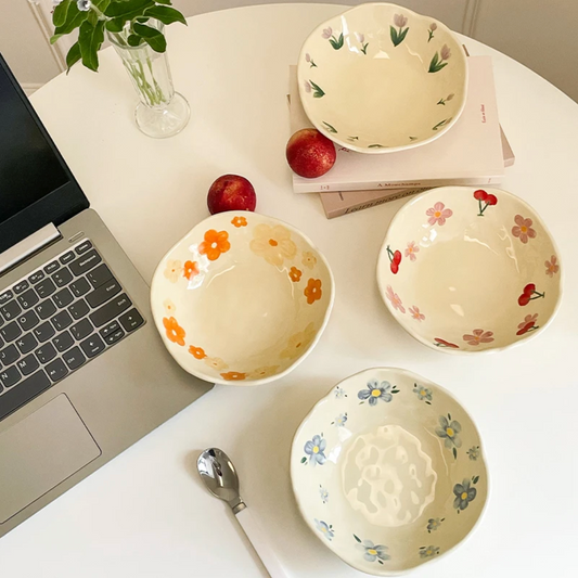 A top view of the four Plantish Wonky Flower Bowls - Blue Flower, Orange Flower, Purple Tulip, Cherry Blossom. All on a white table.