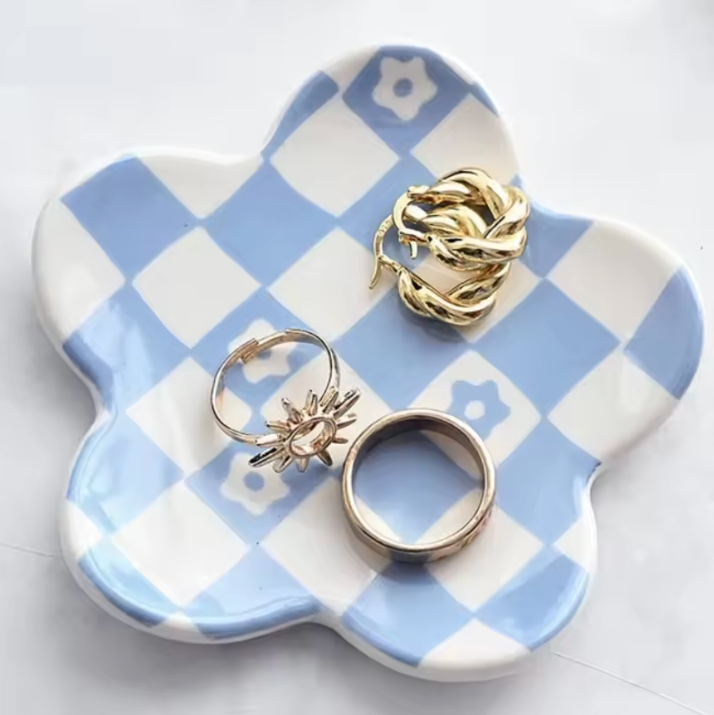 The Plantish Checkered Petal Jewellery Dish in Small Blue Check design, with rings on the dish and the dish against a white background. 