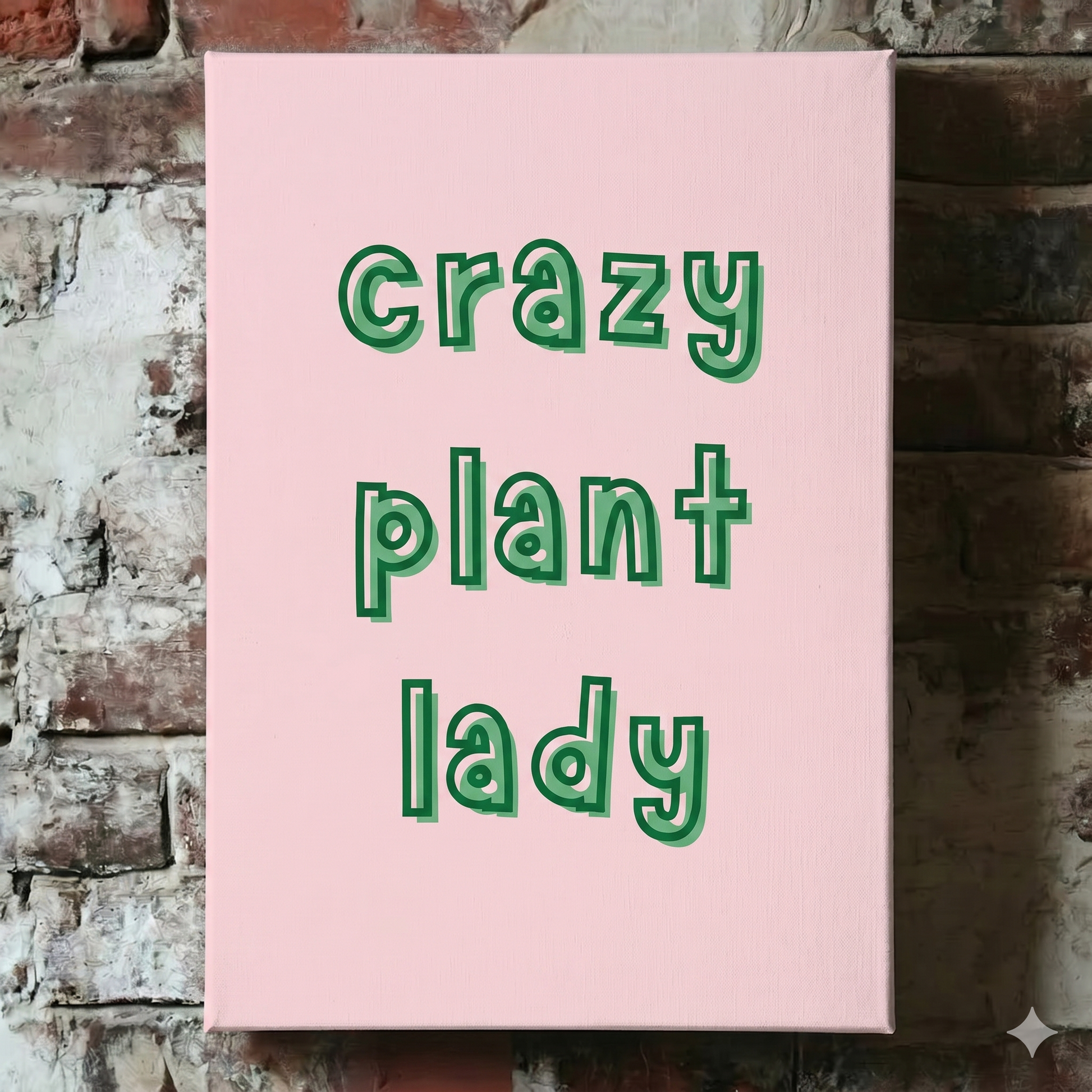 A Plantish canvas of the phrase "Crazy Plant Lady" in a green font with pink background, shown hanging on a red brick wall.