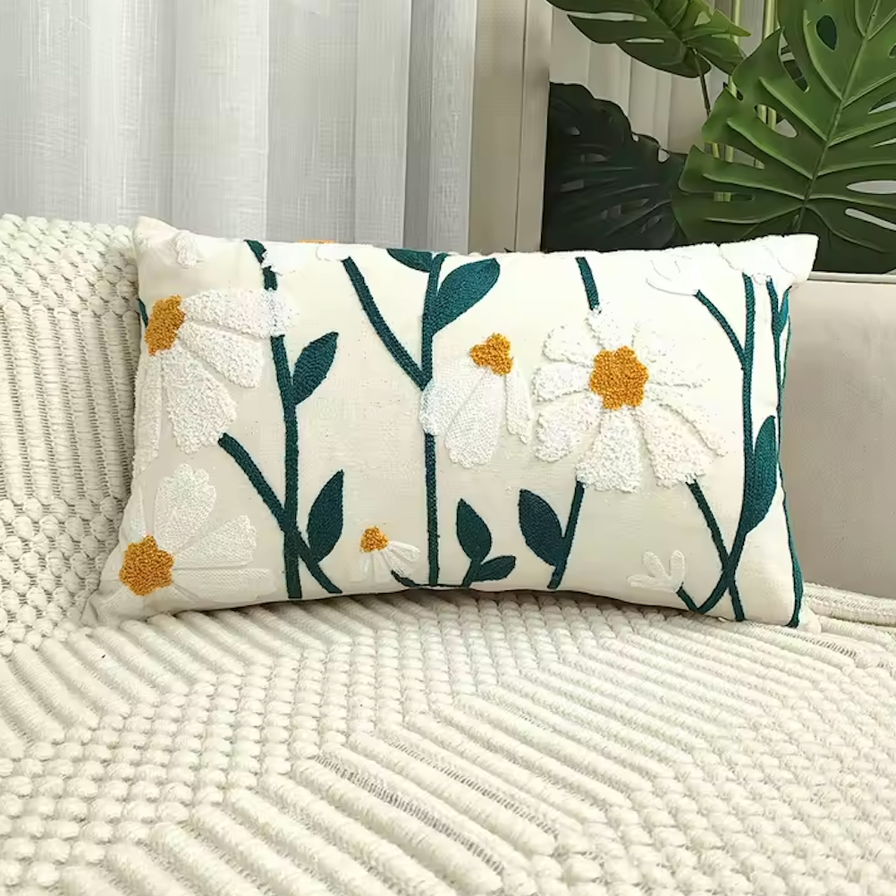 The Rectangular Plantish Embroidered Daisy Cushion Cover in Big Daisy design, positioned on a white sofa monstera plant in the background.