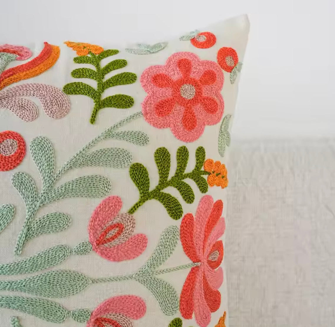 The Plantish Embroidered Sage Flower Cushion,  showcasing the pink and red flowers, green leaves and sage stems against a white background. 