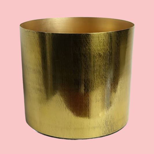 Top view of the Plantish Gold Etched Metal Pot, showing the geometric pattern on the sides, and inside of the pot. The pot is on a block pink background. 