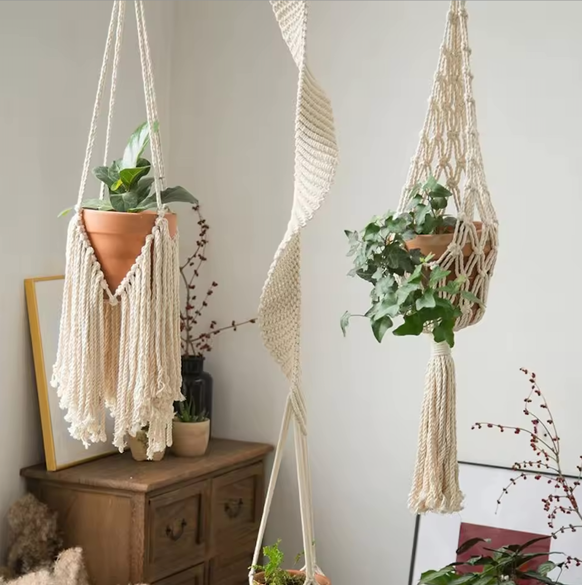 Three Plantish macrames hanging in front of the corner of a bedroom, showing the Helix Macrame, Crosshatch Macrame, and Fringe Macrame. 