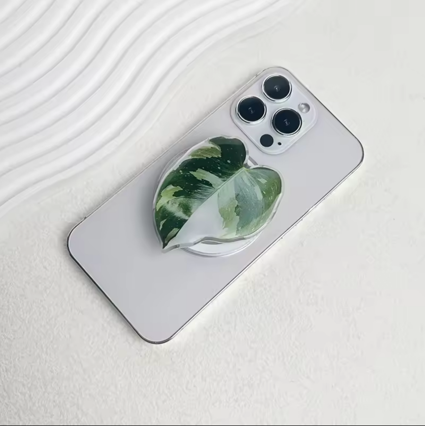 The Plantish White Knight pop socket attached to the back of a white iPhone.
