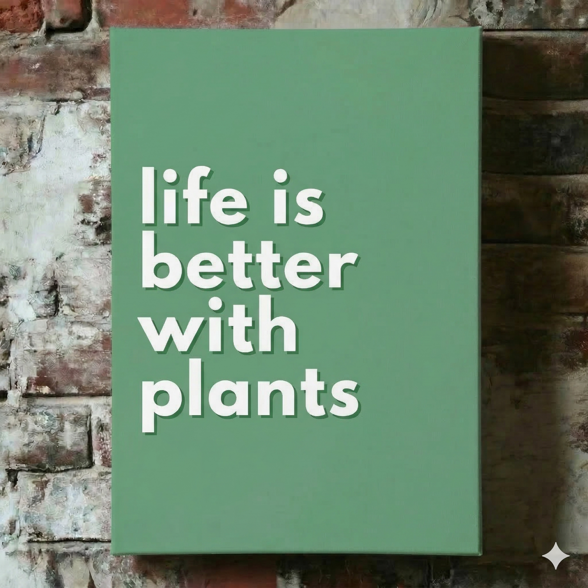 A Plantish canvas of the phrase "Life is Better With Plants" in a white font with green background, shown hanging on a red brick wall.