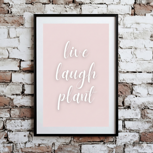 A Plantish print of the phrase "Live Laugh Plant" in a white script font on a pink background, mounted on a brick wall.