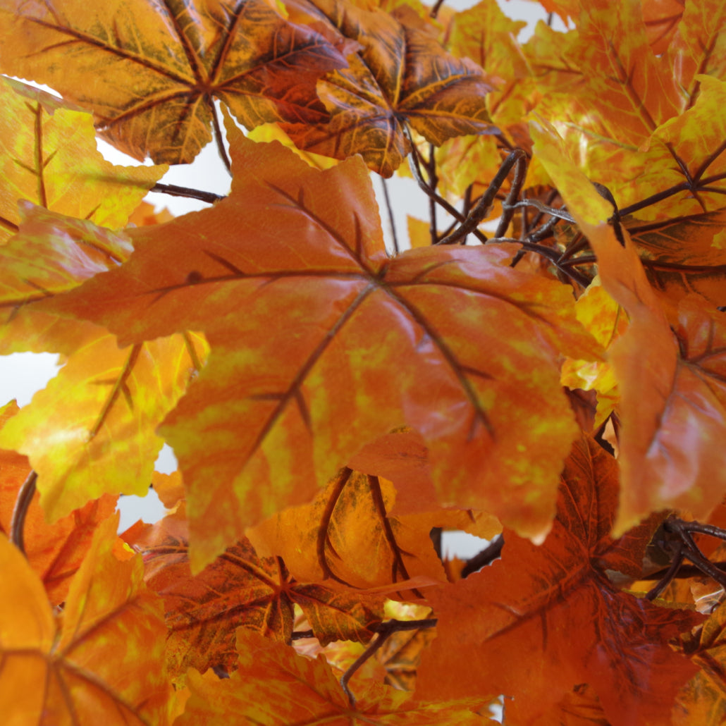 A close up of the orange leaves of the Plantish artificial maple tree, showing off the subtle orange, yellow and brown tones.
