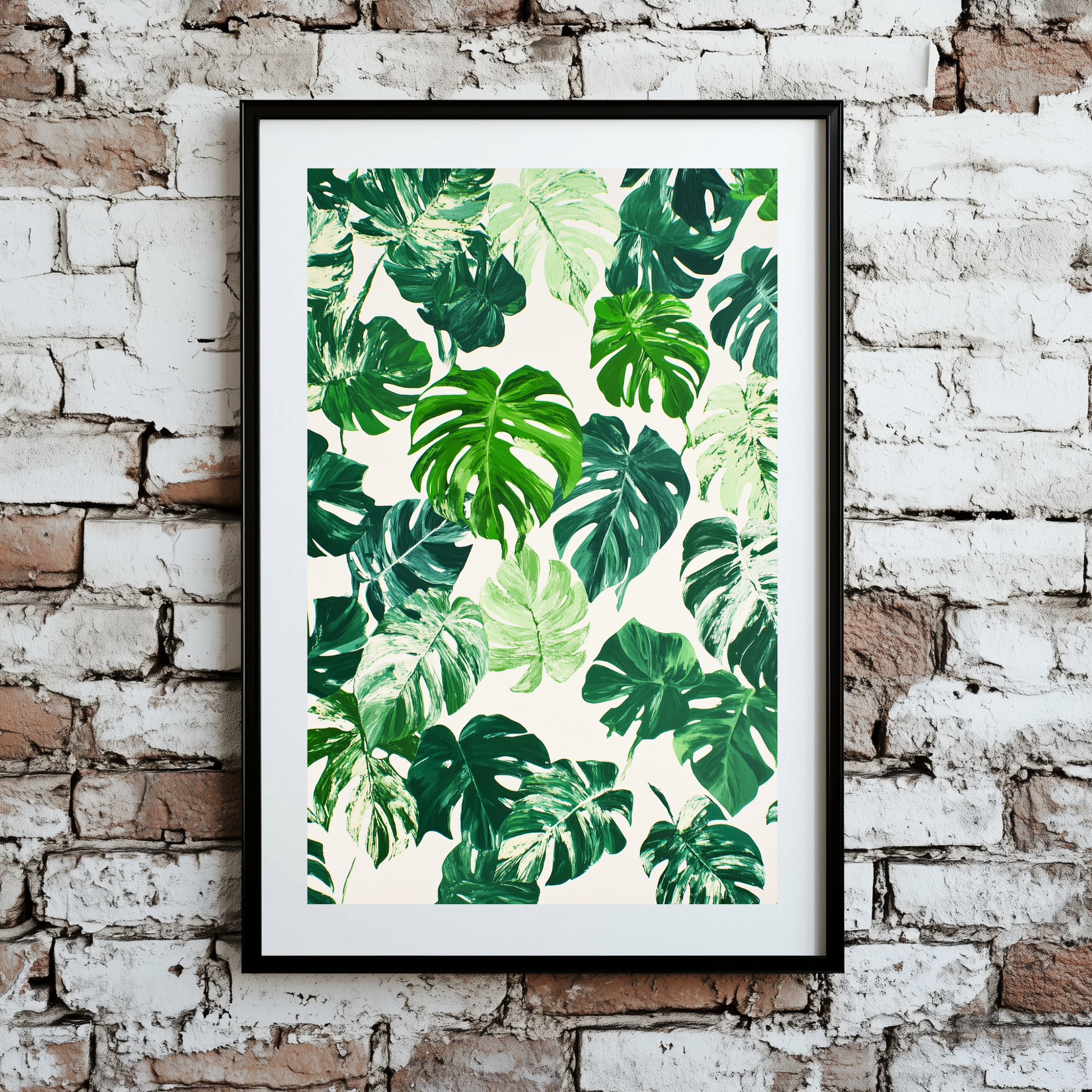 A vibrant and bright plant pattern print of monstera leaves, in different shades of green and some variegated with white, framed on a brick wall.