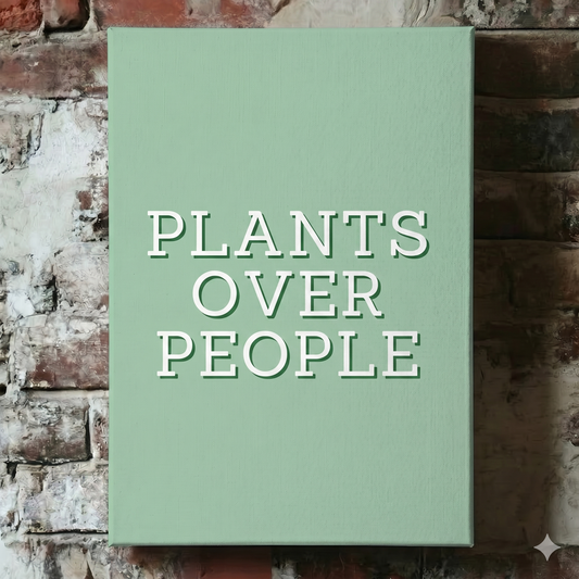 A Plantish canvas of the phrase "Plants Over People" in a white font with a green background, shown hanging on a red brick wall.