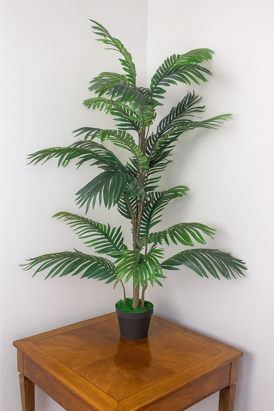 The Plantish artificial palm tree shown in the corner of a white room and placed on a square wooden table. The plant is in a plain black plastic pot.