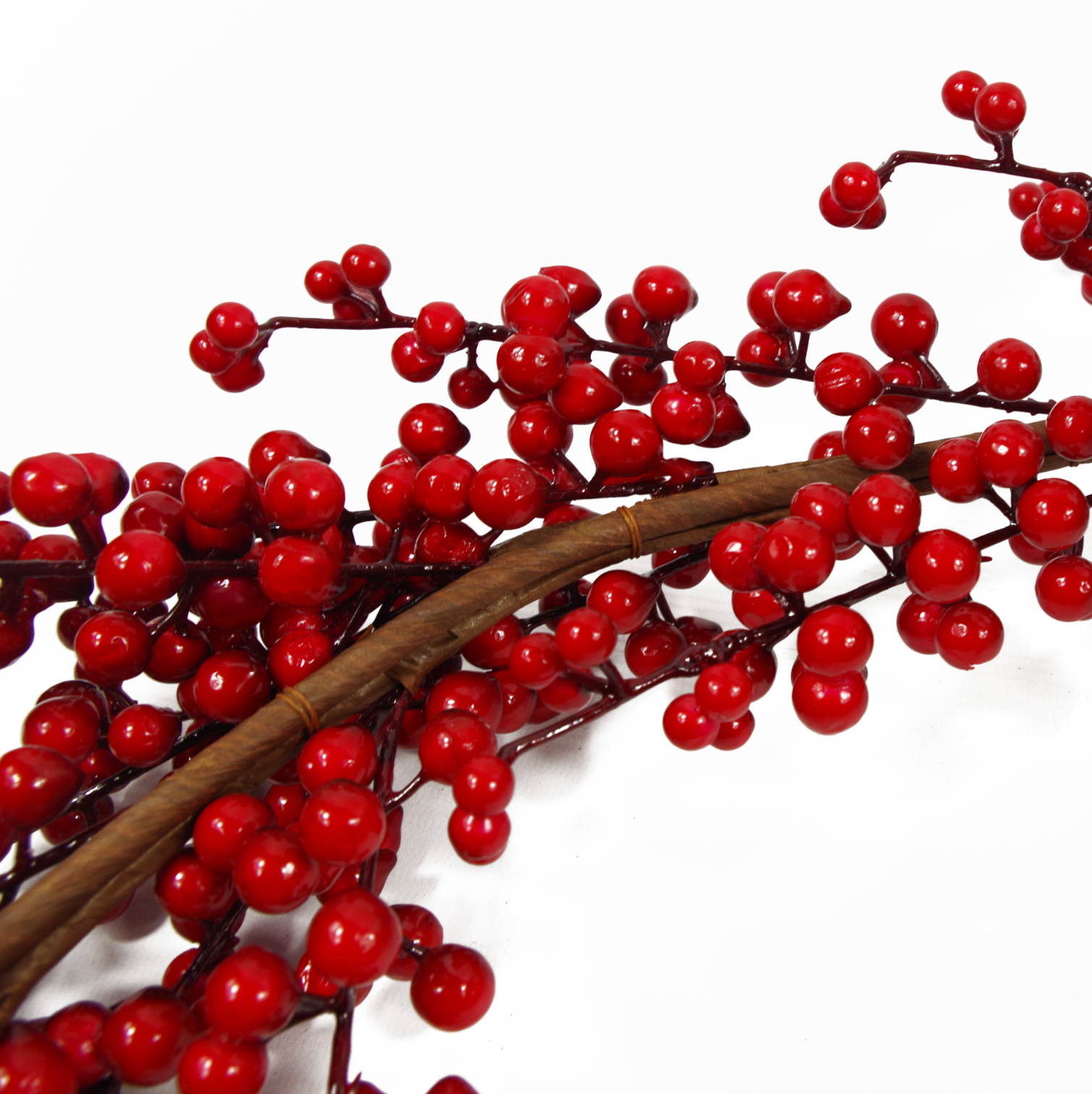 A close up of the Plantish Red Winter Berry Garland, showing the brown stem design in detail as well as the dark red berries.