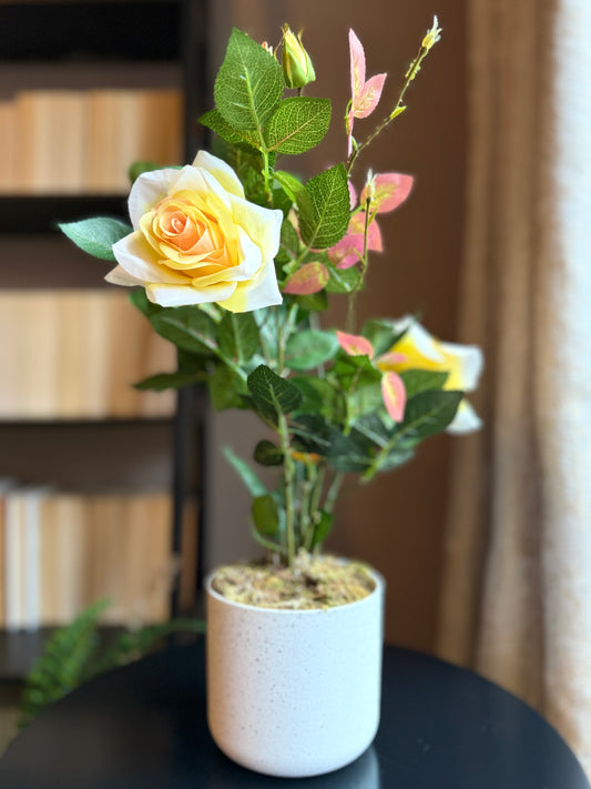 Front view of the Plantish artificial yellow rose, showcasing vibrant yellow blooms, realistic green leaves, and delicate stems, potted in a decorative white plastic pot.