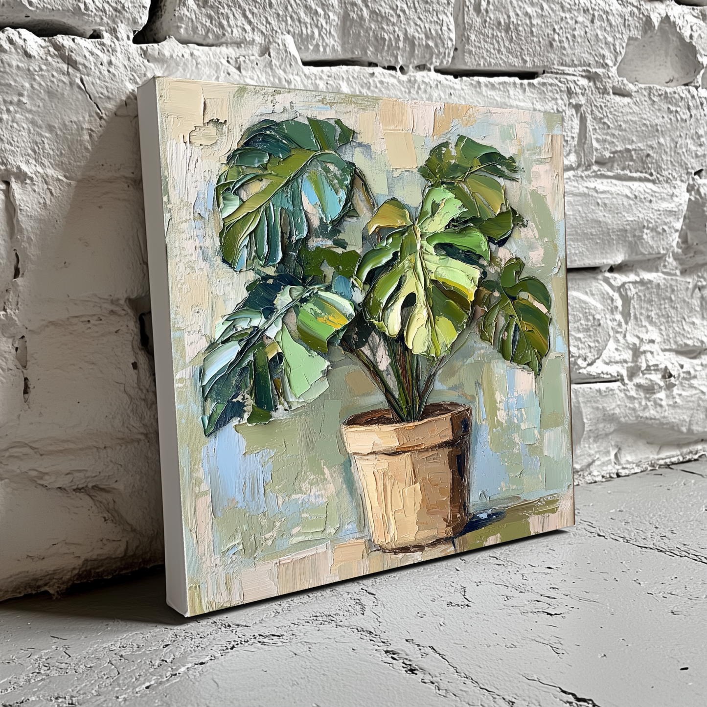 A neutral acrylic canvas of a green monstera in a brown pot with an abstract white cream and blue background, resting on a brick wall. 