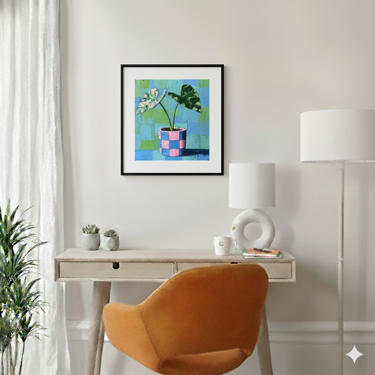 An acrylic painted style print of a variegated green alocasia in a blue and pink checked pot with a green and blue background, in a bright modern desk area