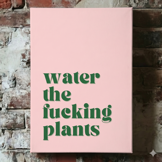A Plantish canvas showing the phrase "Water the Fucking Plants" in a green font against a pink background, hanging on a red brick wall.