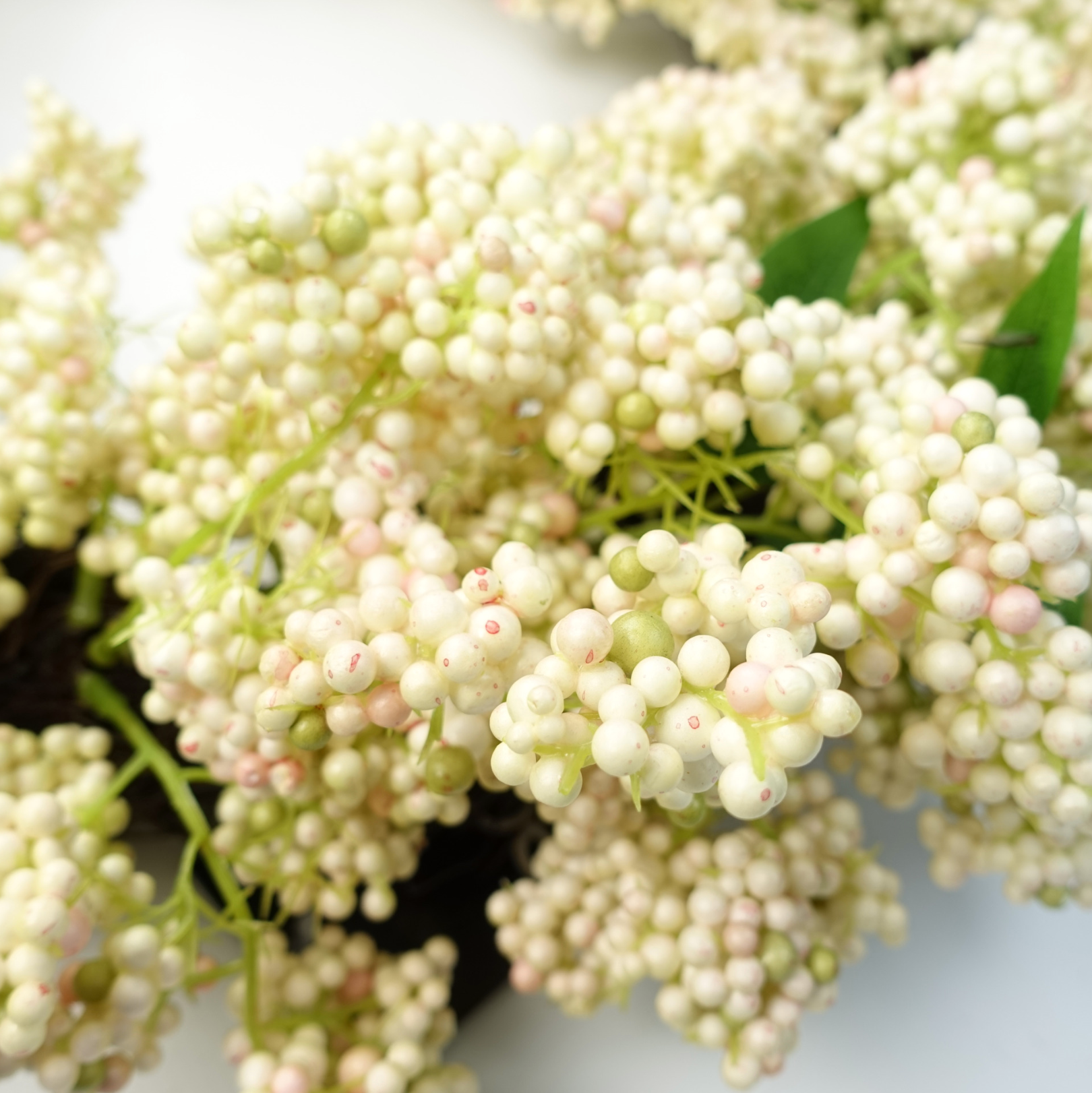 A close up of the Plantish 55cm White Berry Wreath, showing the white berries in a lot of detail. 