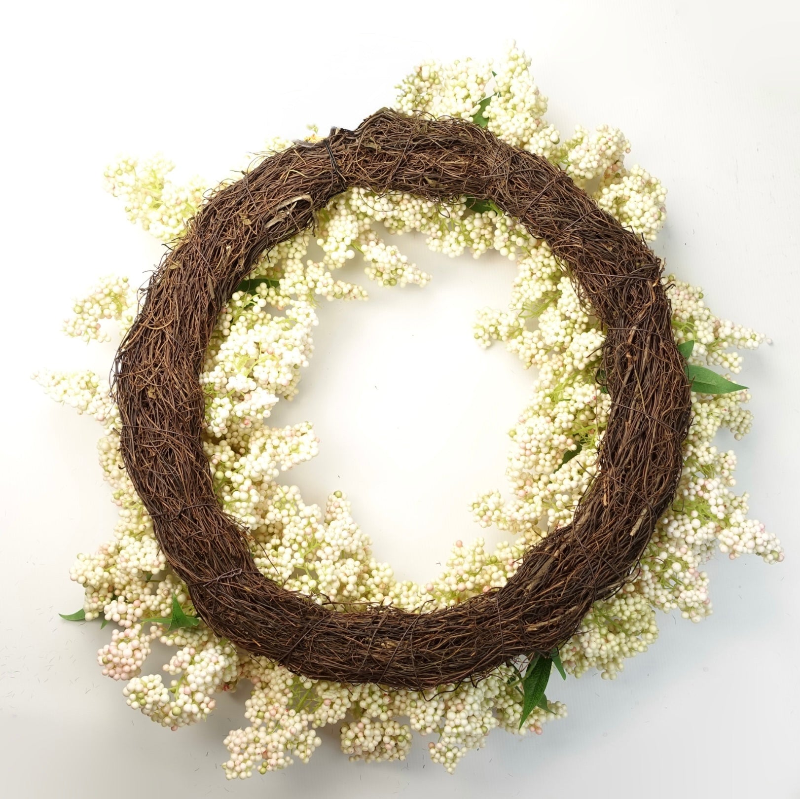 The Plantish 55cm White Berry Wreath shown rear-on, highlighting the white berries and green leaves, as well as the natural woven ring. 